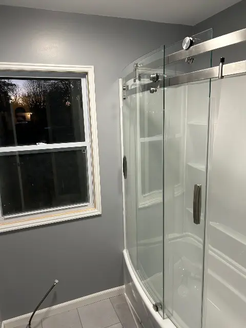Modern glass shower enclosure in updated bathroom setting