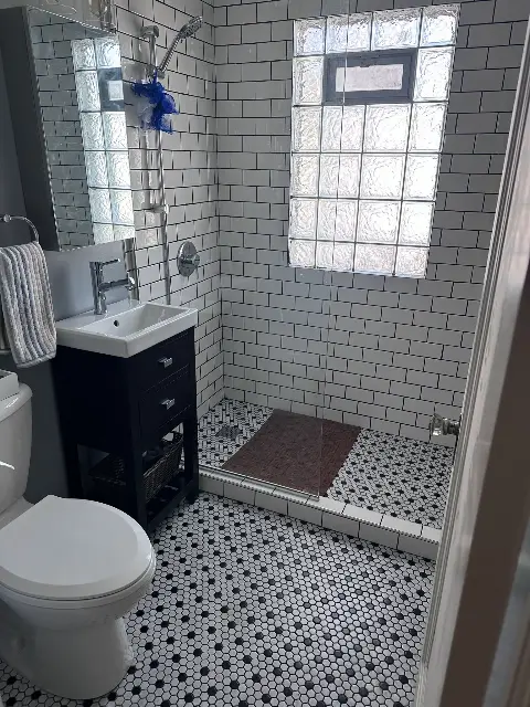 Updated bathroom featuring subway tiles and glass block window